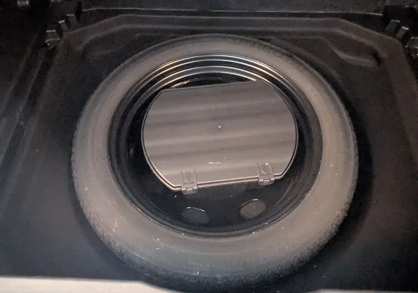 Gros plan sur la roue de secours dans le coffre du Citroën C5 Aircross 2024 gris Artens, avec boîte auto diesel.