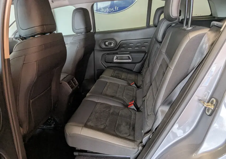 Vue intérieure côté droit des sièges arrière en cuir noir du Citroën C5 Aircross gris Artens 2024, avec détails de la porte.