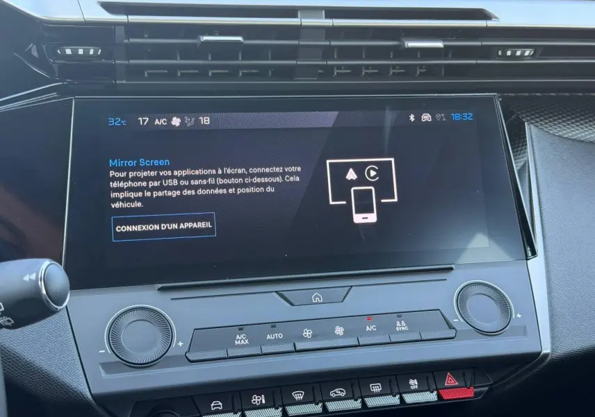 Écran tactile central et commandes climatisation de la Peugeot e-308 noire, vue intérieure frontale rapprochée.