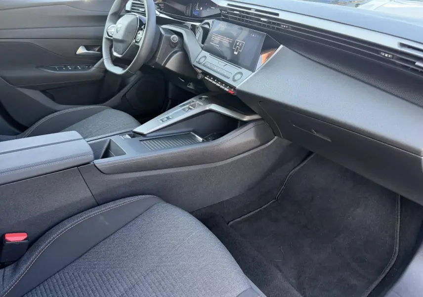 Intérieur avant droit de la Peugeot e-308 2025 noir Perla Nera, avec tableau de bord moderne et écran tactile central.