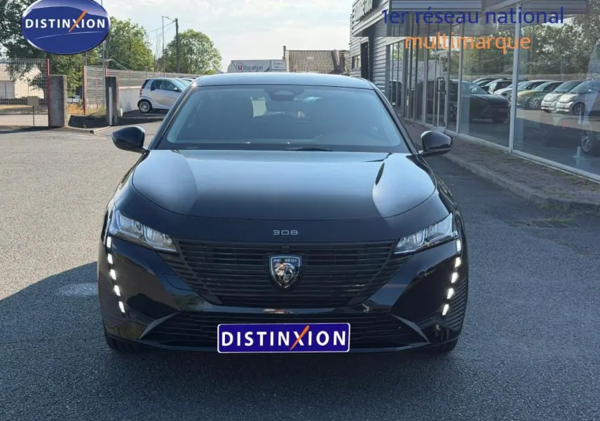 Vue avant d'une Peugeot 308 e-308 noire Perla Nera avec feux LED diurnes verticaux allumés.