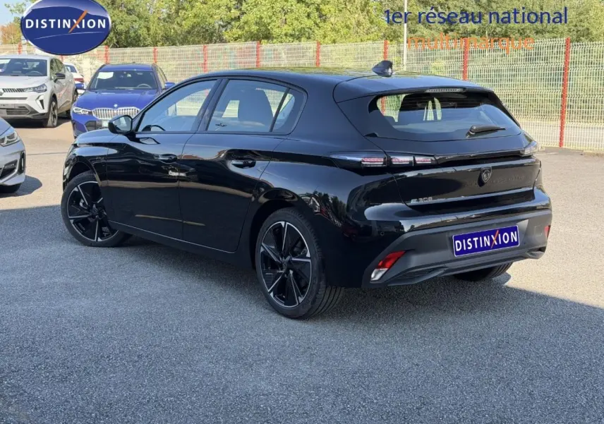 Vue 3/4 arrière droite d'une Peugeot e-308 noire Perla Nera avec jantes alliage et feux arrière LED distinctifs.
