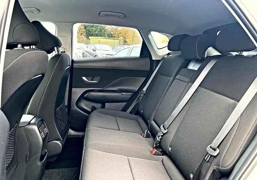 Vue intérieure côté droit de la banquette arrière noire du Hyundai Kona 2025 avec appuie-têtes et ceintures visibles.