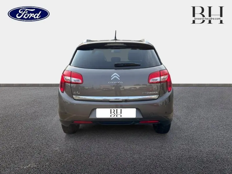 Vue arrière d'une Citroën C4 Aircross brun Mangaro avec feux rouges et lunette arrière surteintée.