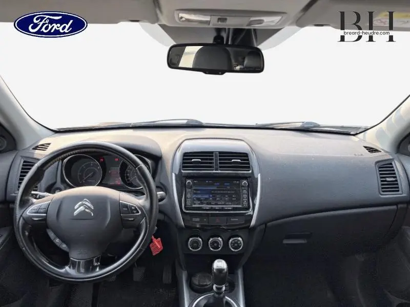 Vue intérieure avant du tableau de bord et volant cuir noir d'une Citroën C4 Aircross 2016 avec boîte manuelle.