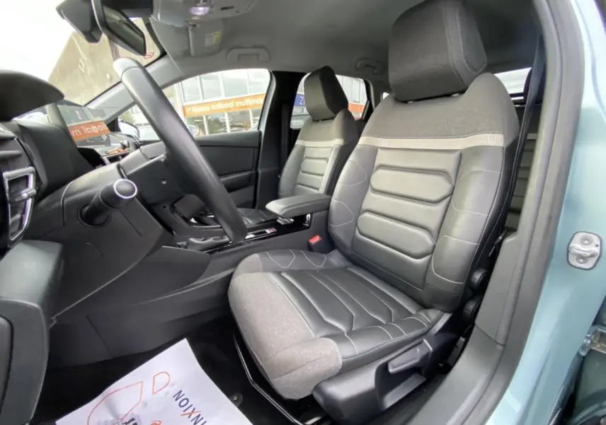 Vue intérieure côté conducteur de la Citroën C4 2021 bleu Iceland, sièges bi-matière gris et noir avec accoudoir central.