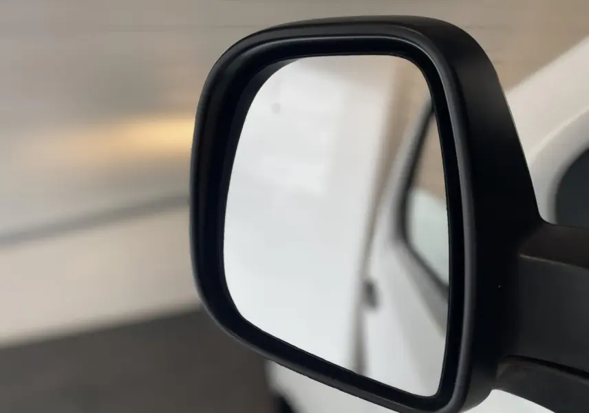 Rétroviseur extérieur droit noir du fourgon blanc Opel Vivaro 2021, vue rapprochée sur fond flou.