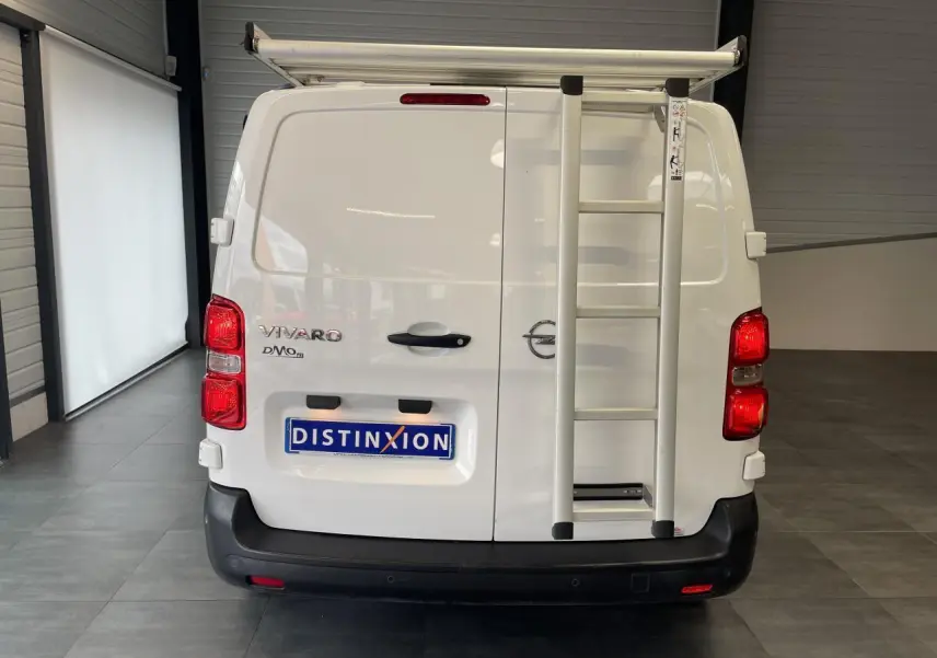 Vue arrière d'un fourgon blanc Opel Vivaro 2021 avec échelle fixée sur la porte droite et bouclier noir.