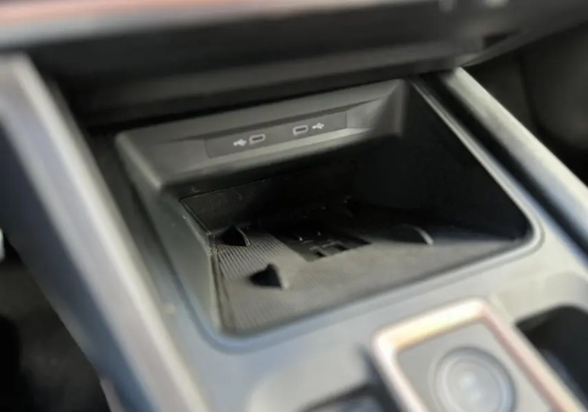 Gros plan sur la console centrale du CUPRA Formentor gris magnétique, mettant en valeur la zone de recharge et ports USB.