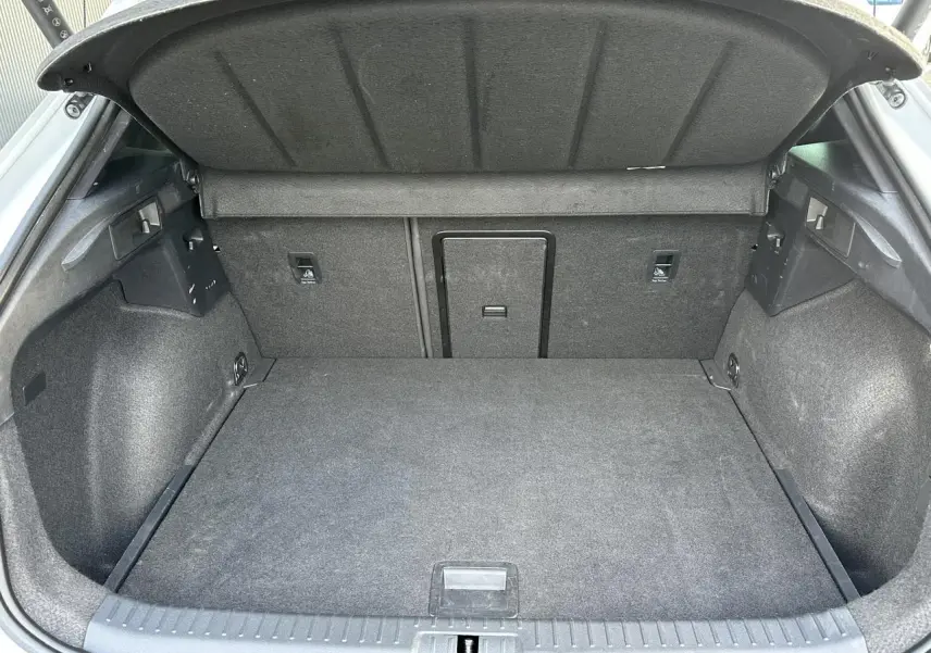 Coffre ouvert vu de l'arrière du CUPRA Formentor gris Magnétique, montrant l'espace de chargement et la trappe à skis.