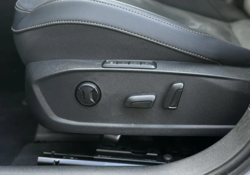 Gros plan sur les commandes électriques du siège conducteur en suédine noir asphalte du CUPRA Formentor gris magnétique.