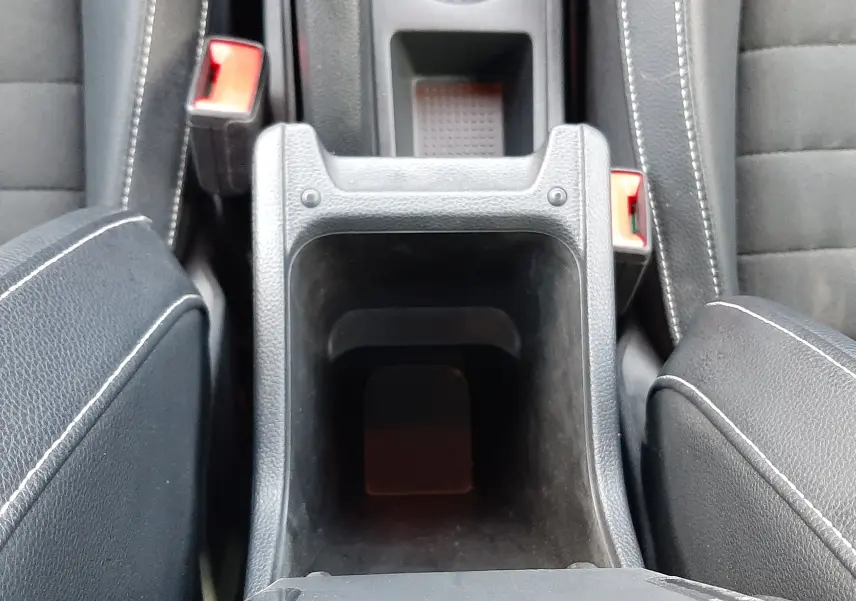 Vue plongeante sur le rangement central noir entre les sièges avant en tissu et cuir noir du SEAT Arona 2025.