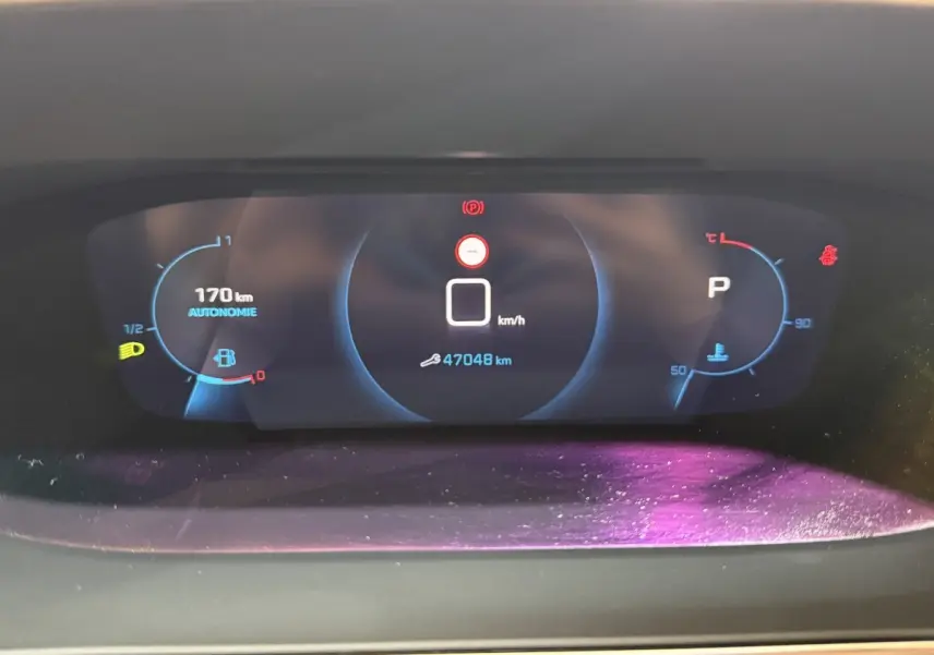 Tableau de bord numérique du Peugeot 2008 2023 affichant vitesse, autonomie et température moteur.