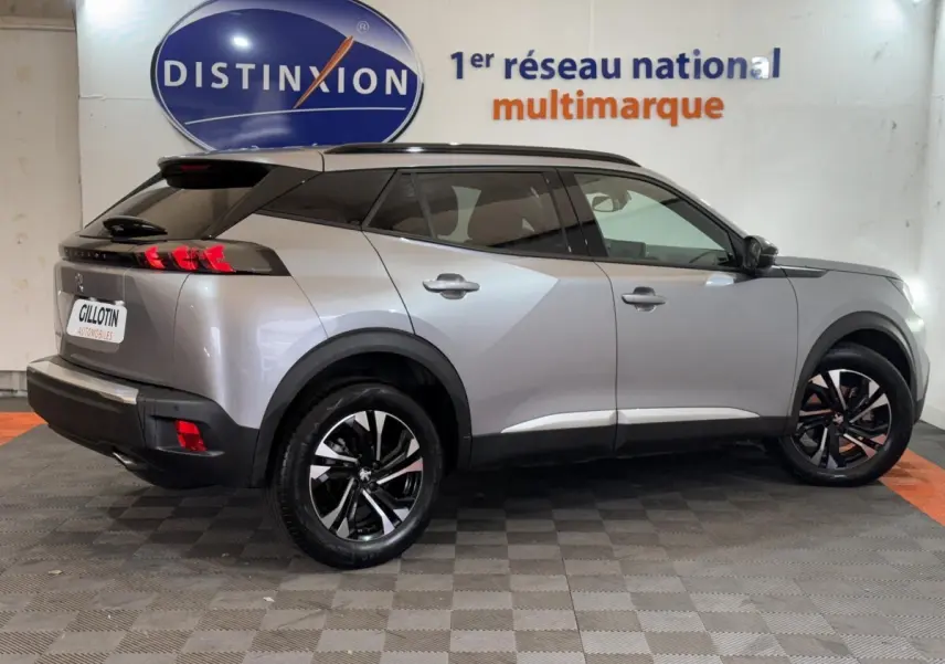 Peugeot 2008 gris clair vue de profil droit, mettant en valeur ses jantes noires et son toit noir contrastant.