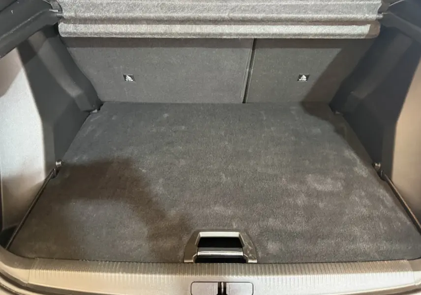 Coffre vide en vue plongeante d'un Peugeot 2008 gris clair, soulignant l'espace de rangement et la tablette arrière.