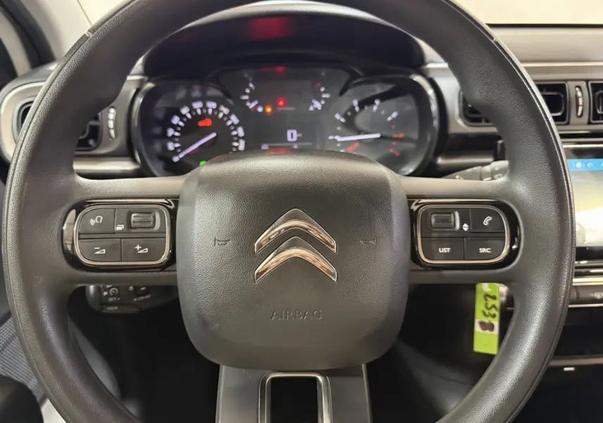 Vue rapprochée du volant multifonctions noir de la Citroën C3 2021 avec tableau de bord et commandes visibles.