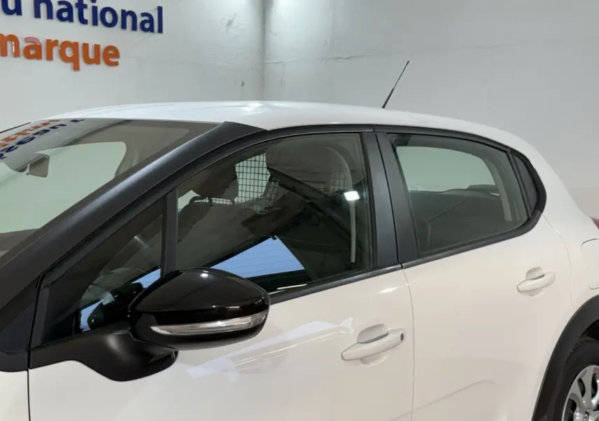 Vue latérale gauche d'une Citroën C3 blanche 2021 avec rétroviseur noir et poignées de porte assorties.