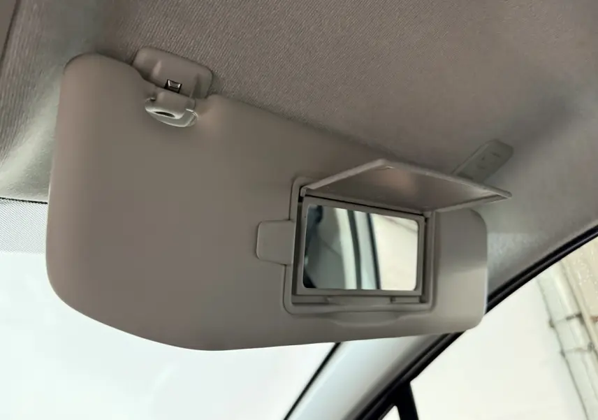 Détail du pare-soleil côté conducteur avec miroir de courtoisie ouvert dans une Citroën C3 blanche de 2021.