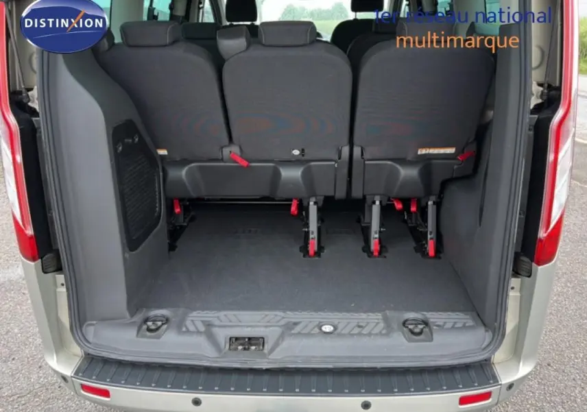 Vue arrière du Ford Tourneo Custom gris foncé, montrant l'espace de chargement et les sièges arrière rabattus.