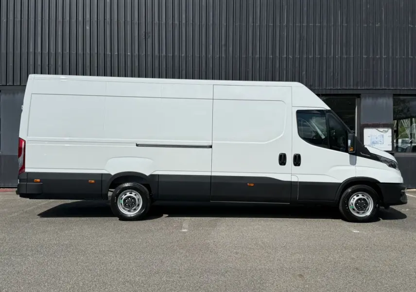 Fourgon Iveco Daily blanc vu de profil côté droit, avec bas de caisse noir et jantes acier simples.