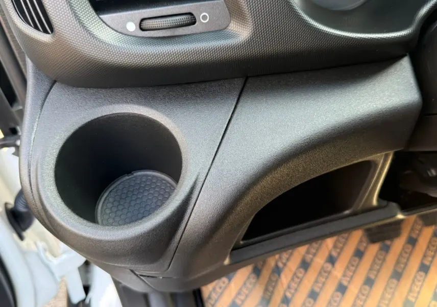 Gros plan sur le rangement et porte-gobelet côté droit de l’habitacle du fourgon blanc Iveco Daily 35S18 2026.