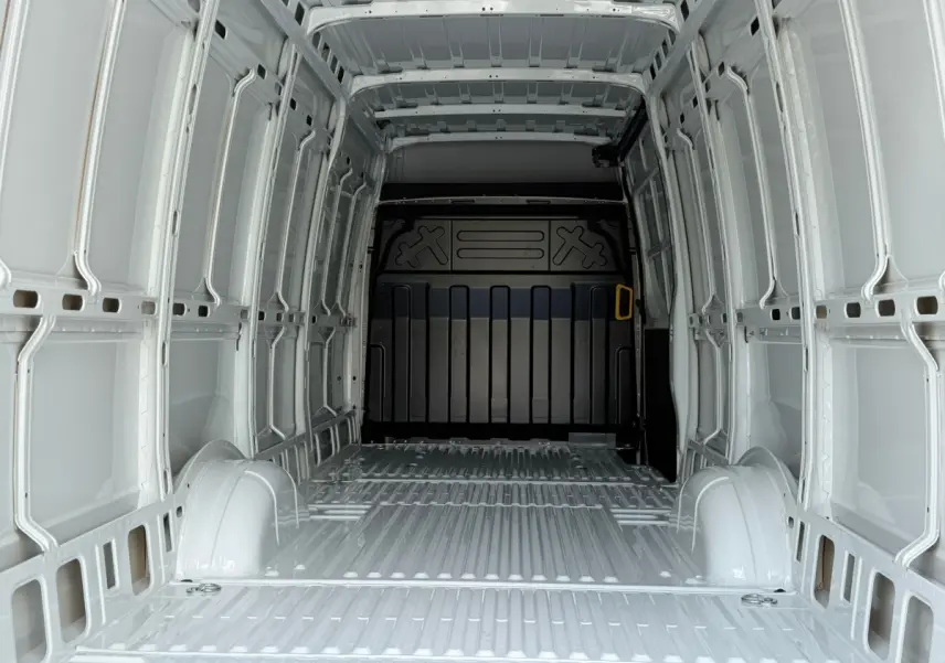 Vue intérieure de la cabine arrière blanche d’un Iveco Daily 35S18 3.0 V16 Himatic BVA H2, montrant l’espace de chargement vide.