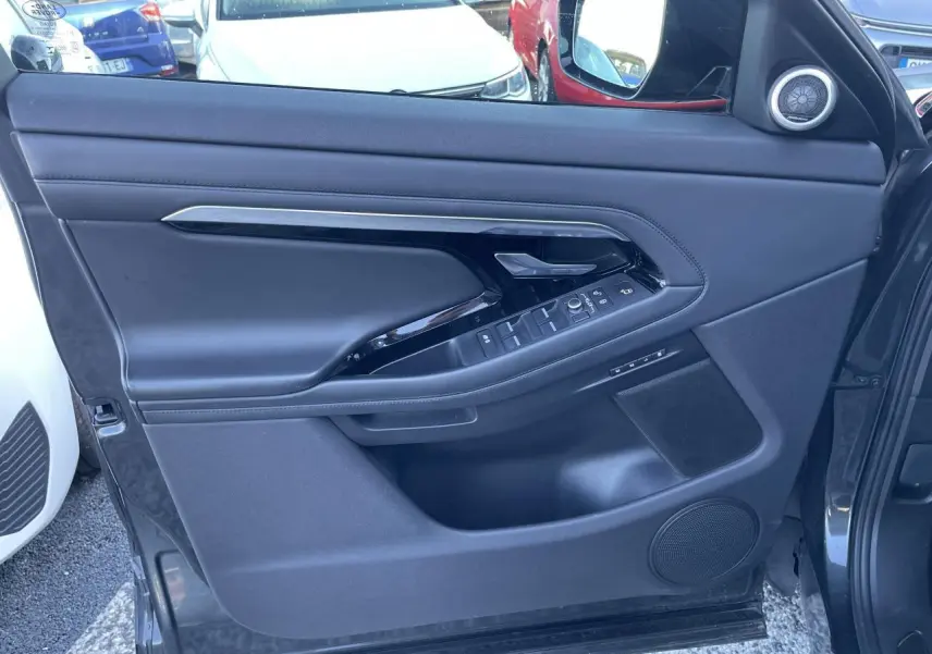 Porte côté gauche du Range Rover Evoque gris, avec commandes électriques et haut-parleur intégré visible.