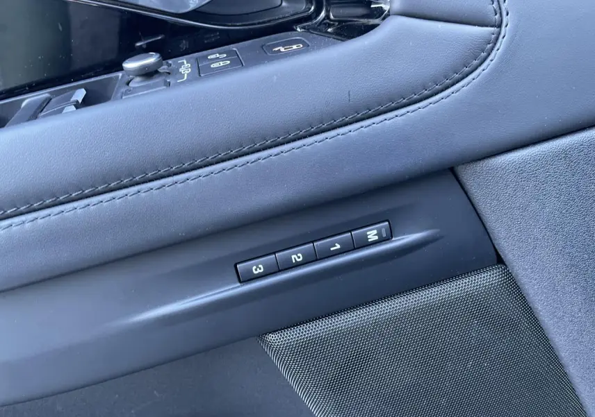Détail des commandes de mémoire des sièges sur la portière intérieure en cuir noir du Range Rover Evoque gris.