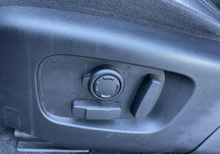 Gros plan sur les commandes de réglage électrique du siège avant droit du Range Rover Evoque gris 2019.