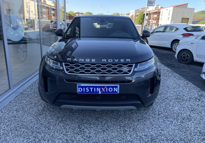Vue frontale d'un Range Rover Evoque gris métallisé avec calandre Dark Atlas et logo Land Rover visible.