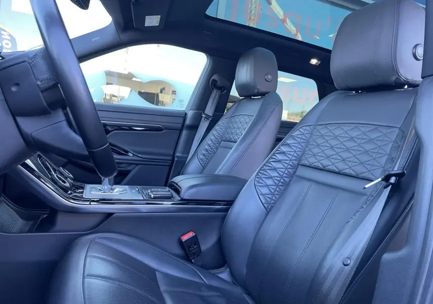 Intérieur cuir noir du Range Rover Evoque 2019, vue côté conducteur avec sièges avant et console centrale.
