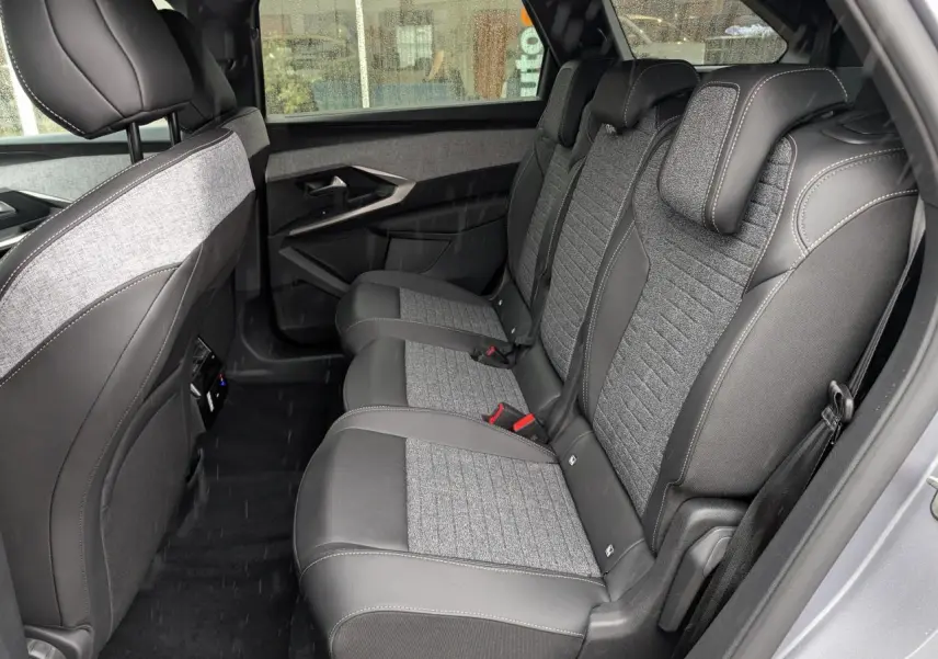Vue latérale intérieure sur la banquette arrière tissu gris et cuir noir du Peugeot 5008 Gris Artense 2025.