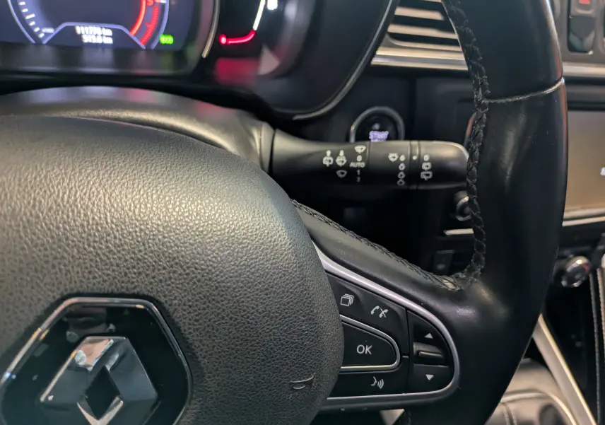 Gros plan sur le volant en cuir noir du Renault Kadjar 2017 avec commandes intégrées et tableau de bord numérique.