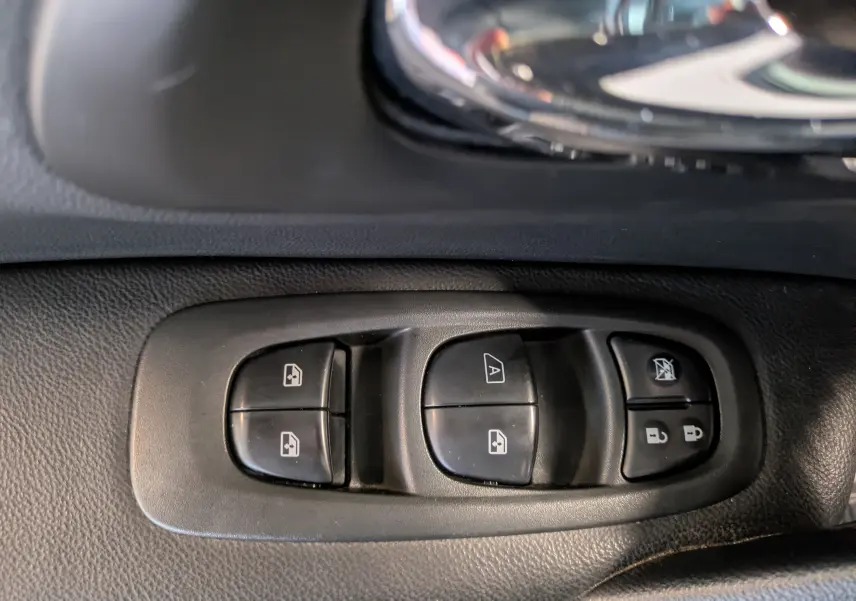 Gros plan sur les commandes de lève-vitres et verrouillage de porte côté conducteur d’un Renault Kadjar gris 2017.