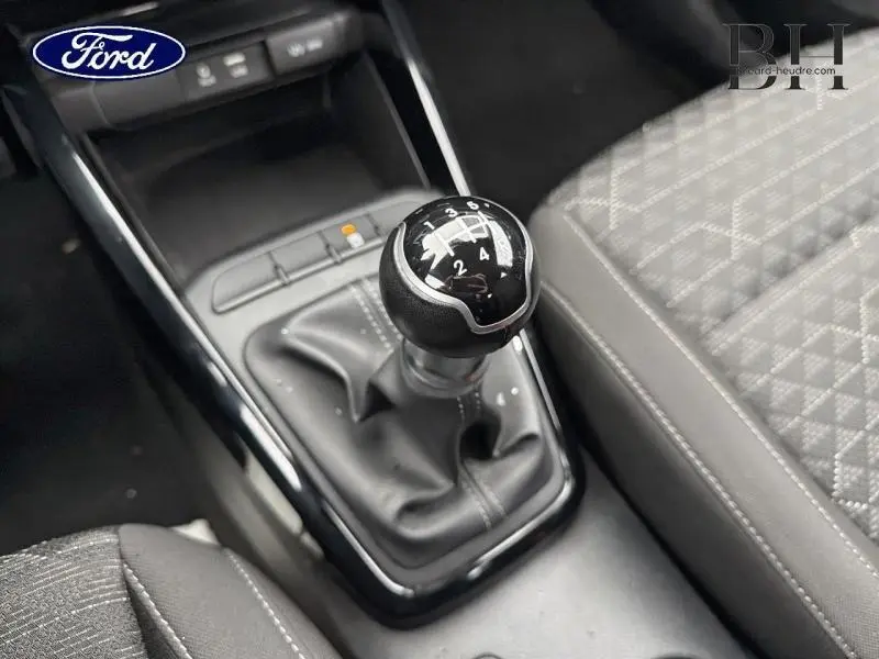 Gros plan sur le levier de vitesses manuel noir et cuir de la KIA Rio 1.2 MPi, avec siège tissu Atlanta gris à motifs.