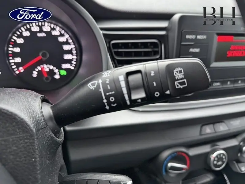 Gros plan sur la commande d’essuie-glace à gauche du volant dans l’habitacle noir d’une KIA Rio 2018.