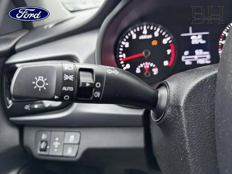 Gros plan sur la commande des phares à gauche du volant dans l’habitacle d’une KIA RIO 2018, tableau de bord en arrière-plan flou.