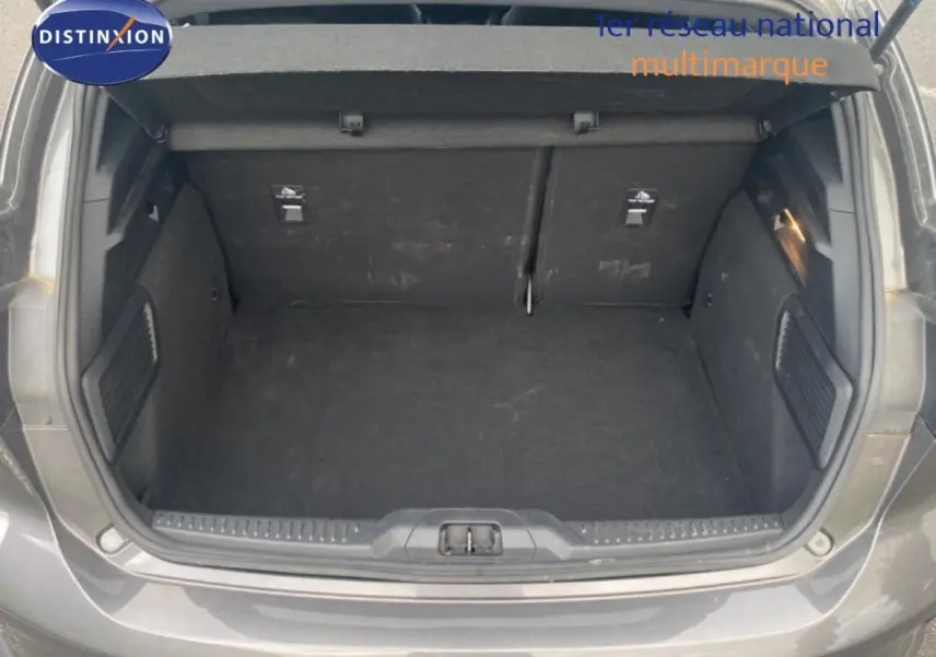 Coffre ouvert vu de l'arrière d'une Ford Focus gris foncé 2024, avec intérieur spacieux et tapis noir.