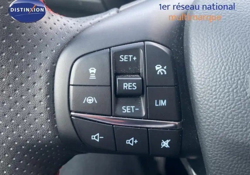 Gros plan sur les commandes au volant à gauche de la Ford Focus gris foncé 2024, avec régulateur de vitesse et assistant maintien.