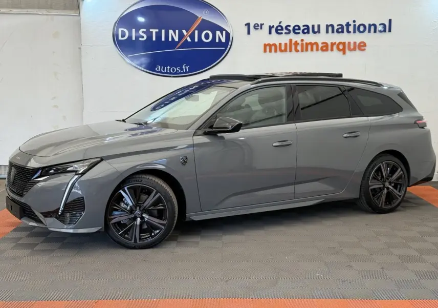 Peugeot 308 Hybrid 136 e-DCS6 GT gris foncé vue de profil côté gauche, avec jantes noires et toit noir.