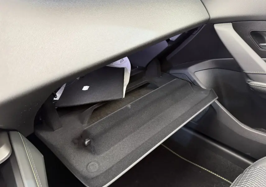 Gant de boîte à gants ouvert côté passager dans l’habitacle gris foncé du Peugeot 308 Hybrid 136 e-DCS6 GT 2024.