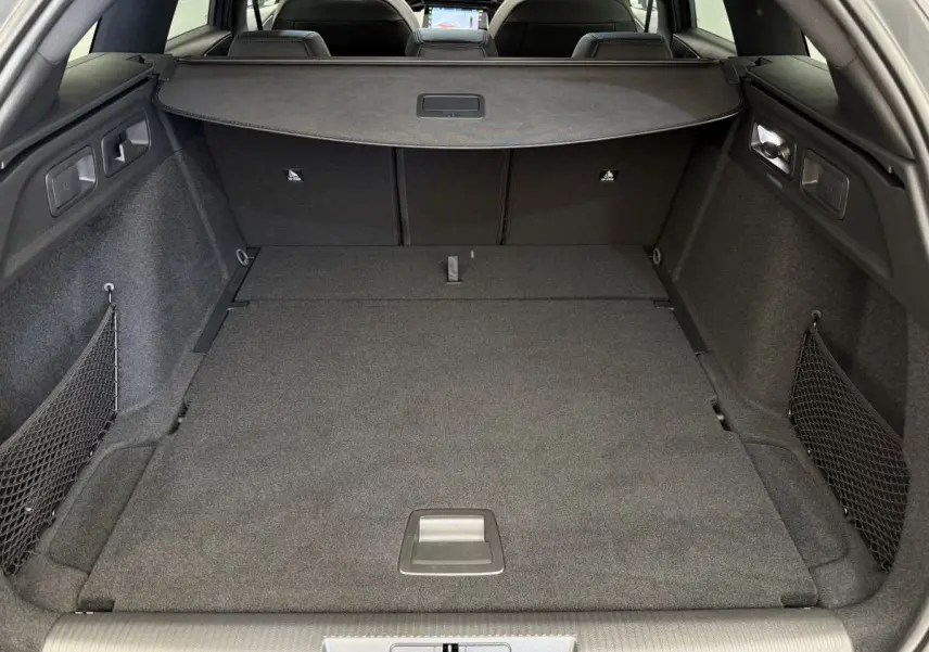Coffre spacieux et plancher plat du Peugeot 308 Hybrid 136 e-DCS6 GT vu de l'arrière, intérieur gris foncé.