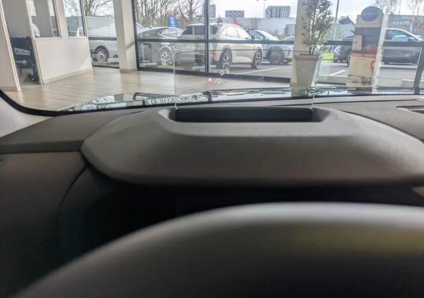 Vue intérieure du tableau de bord de la Citroën C4 hybride 2025, avec affichage tête haute transparent.