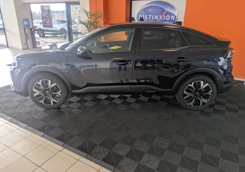 Vue latérale droite d'une Citroën C4 hybride 2025 en bleu Eclipse, avec jantes alliage et intérieur visible.