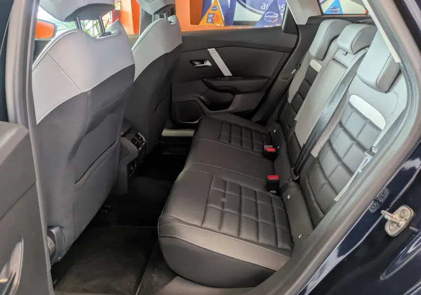 Vue intérieure côté droit des sièges arrière en cuir noir et gris clair du Citroën C4 Hybride 2025 Bleu Eclipse.