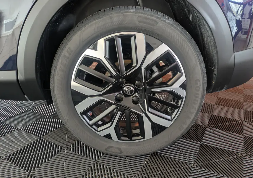 Gros plan sur la jante alliage 18 pouces bicolore noir et argent du côté arrière droit d'une Citroën C4 Bleu Eclipse.