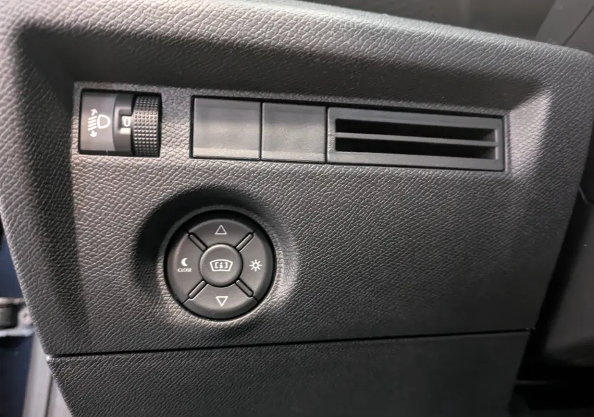 Détail du tableau de bord noir côté gauche avec commandes d’éclairage et ventilation, Citroën C4 Hybride 2025 bleu Eclipse.