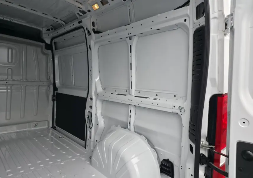 Vue intérieure arrière du fourgon Peugeot Boxer blanc, montrant l'espace de chargement tôlé et la porte ouverte.