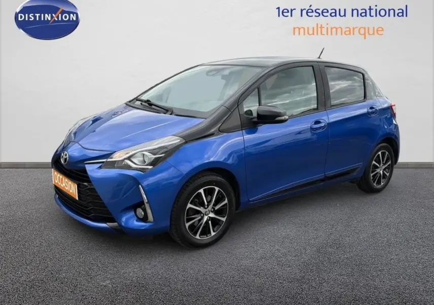 Toyota Yaris bleu foncé vue 3/4 avant droit, avec jantes alliage et phares antibrouillard visibles.
