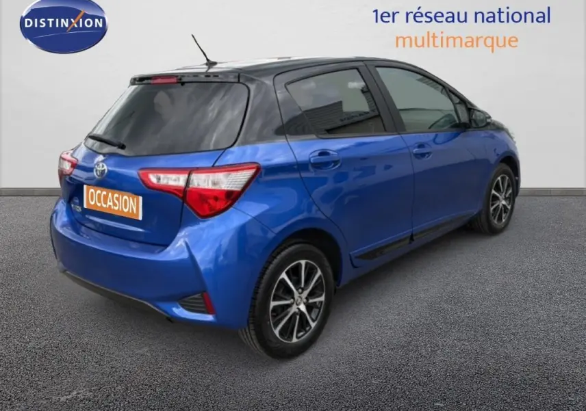 Vue 3/4 arrière droite d'une Toyota Yaris bleu foncé avec jantes alliage et vitres teintées.